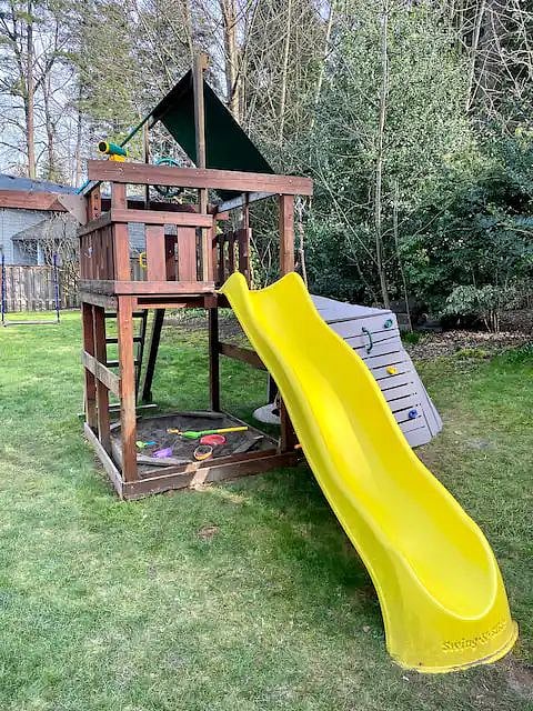 Let the kids get some energy out on this climbing feature, swingset, and slide.