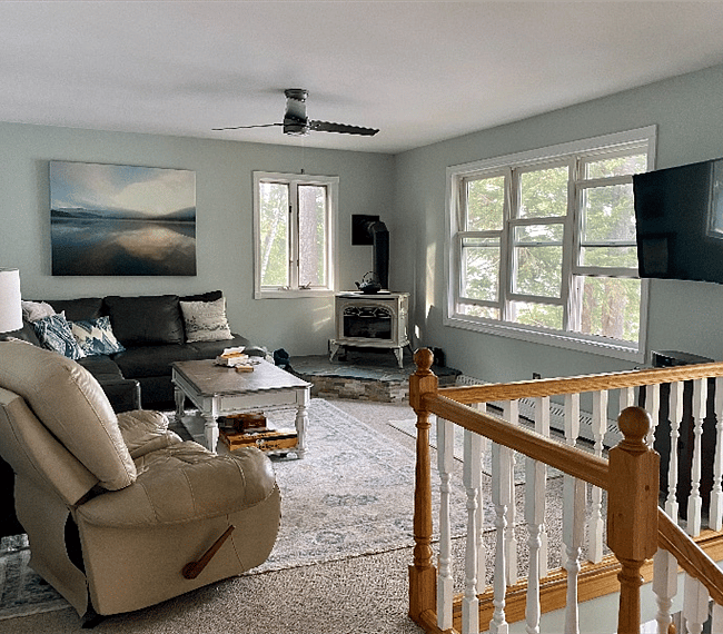 Family room on main level with tv, gas stove and a lovely view of the lake.