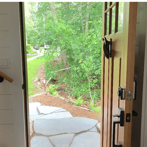 A sandy path leads from the parking area to the cottage.