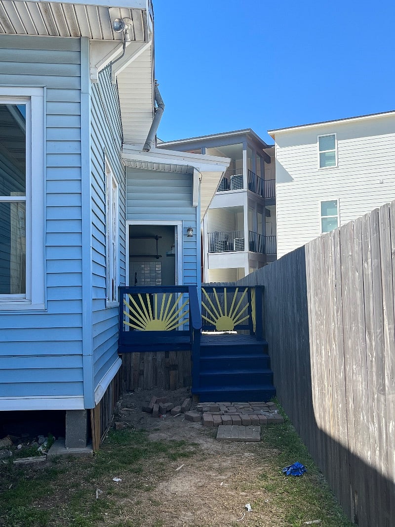 3-4 steps up to the front door, small fenced in courtyard.