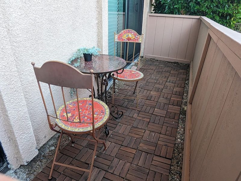 front patio stretches across both bedrooms, accessed by sliding glass doors