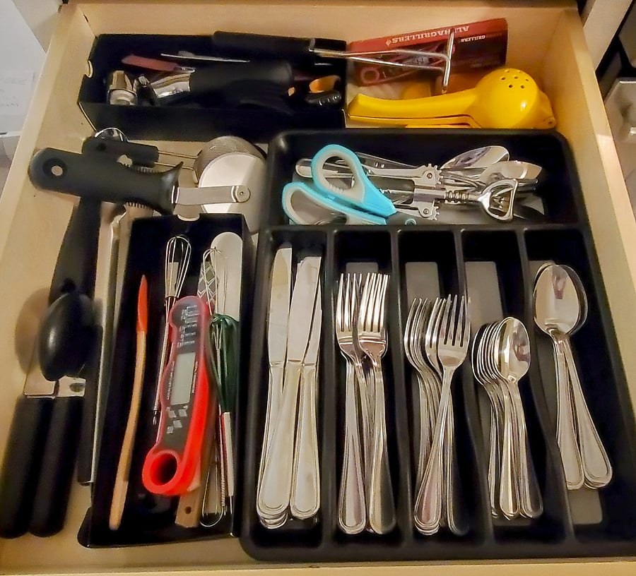 Lots of silverware and other tools, food thermometer, ice cream scoop, scissors, wine opener, juice squeezer, tiny spatulas etc