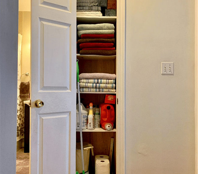 Linen closet with towels, laundry supplies, Swiffer, cleaning supplies
