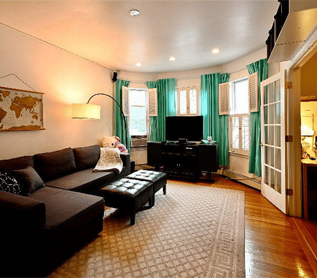 Living room with sectional couch, TV, and a home office