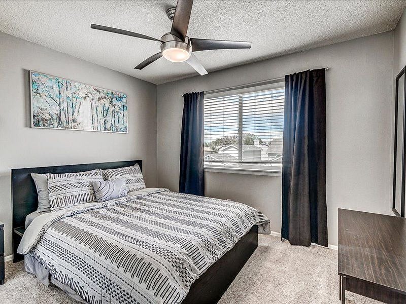 Your bedroom, with blackout blinds, a lighted ceiling fan, a desk, and a full-length mirror