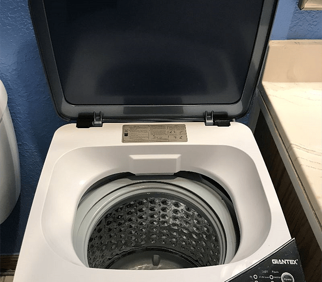 Mini-washer in bathroom, drains to shower.
