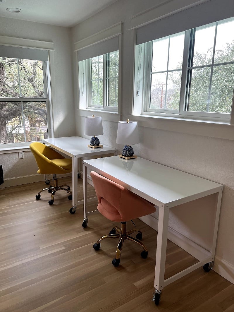 Two desks, two chairs, two lamps. Double work space with lots of natural lights and trees outside every window.