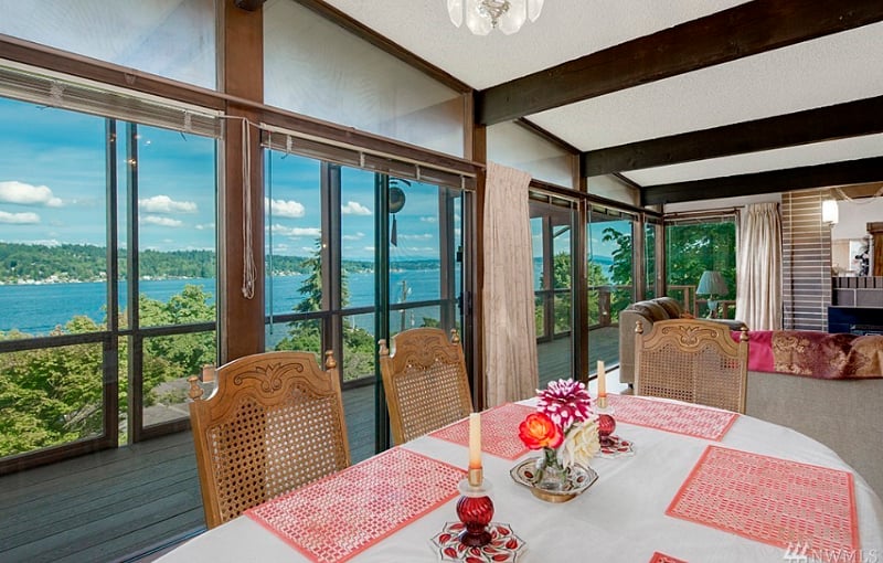 Dining area with deck and living room in background.