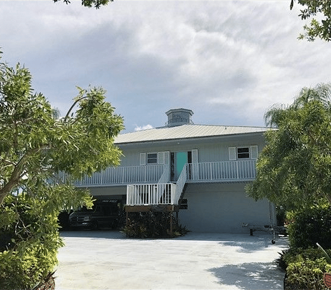 View of front of home, including front stairs.