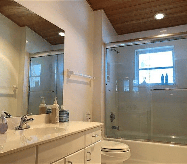 Second bathroom with tub/shower, sink and vanity, toilet, and linen closet.