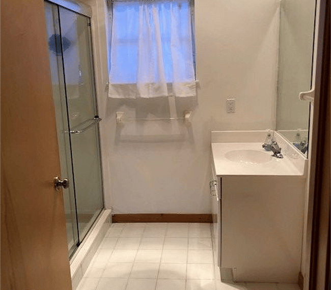 Primary bathroom with shower, sink, vanity, and toilet.