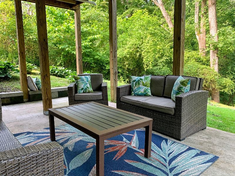 Outdoor patio seating in lush private backyard