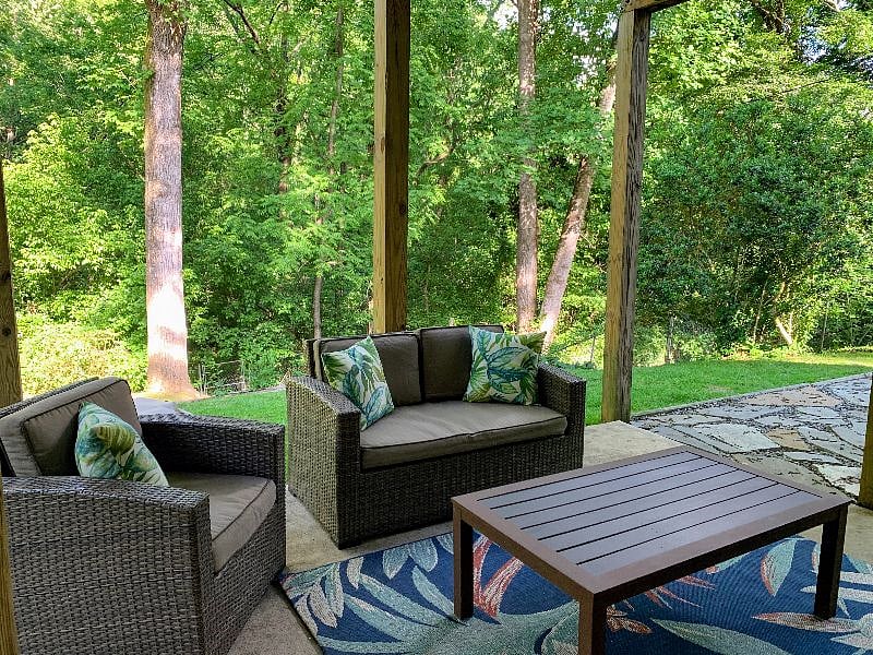 Outdoor patio seating in lush private backyard