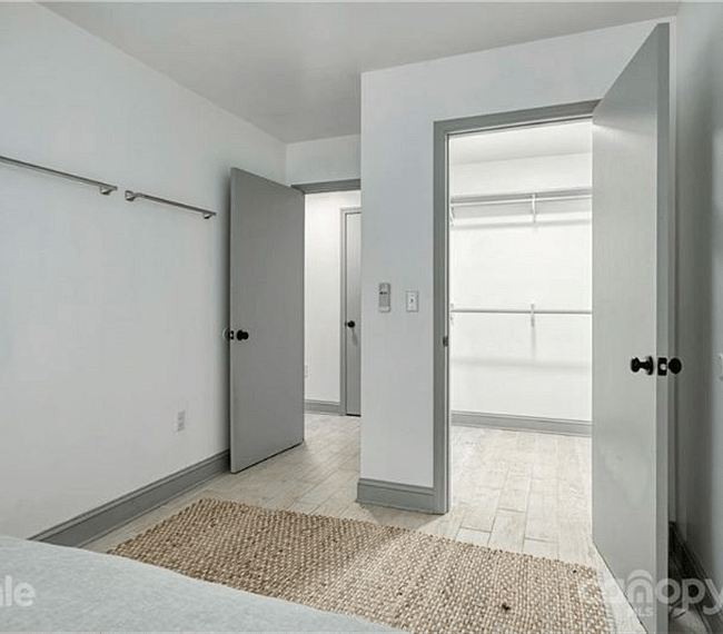 View of walk-in closet in one of the bedrooms
