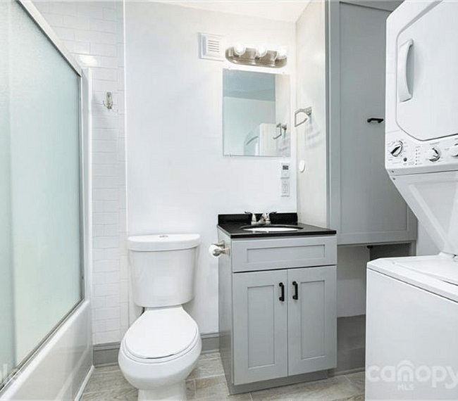 Bathroom with full bathtub and washer/dryer