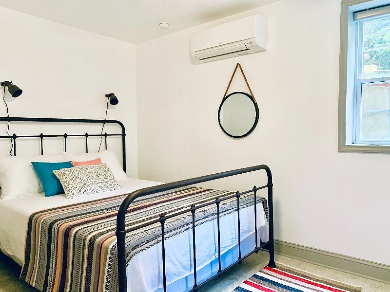 Bedroom with queen-sized bed and dappled sunlight