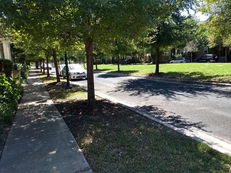 Tree-lined street of Central Austin Row House with plenty of parking out front. The neighborhood pool sits at the end of our block.