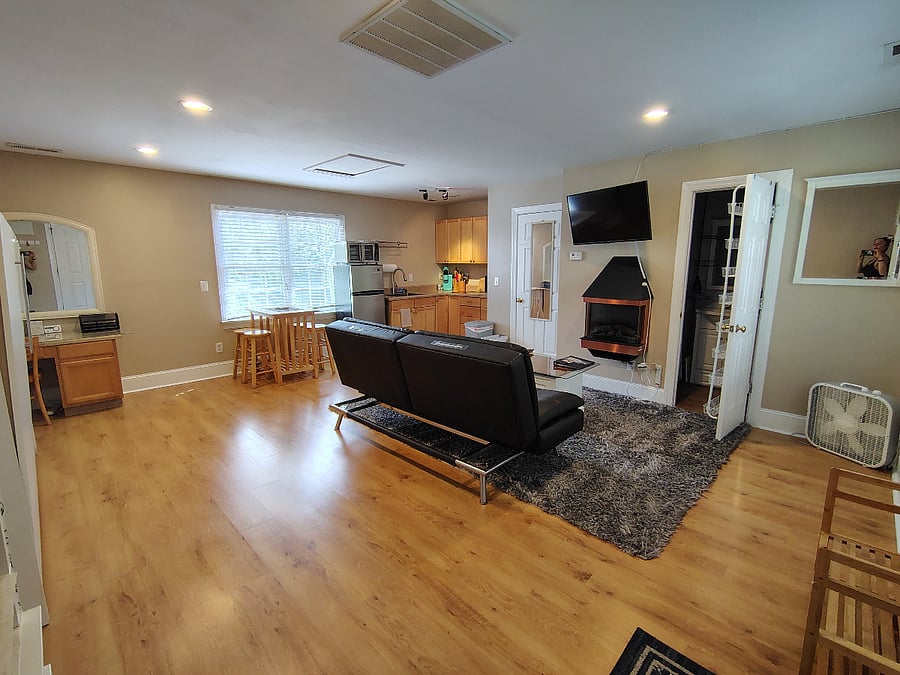 living space has electric fireplace smart tv and lots of natural light