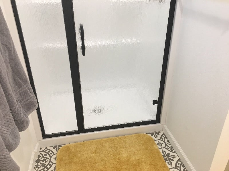 Here is the large walk-in shower with a custom made door featuring rainfall glass.