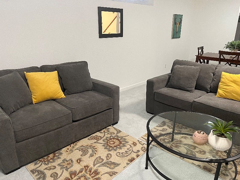Love seat and sofa with coffee table, dining area is just behind.