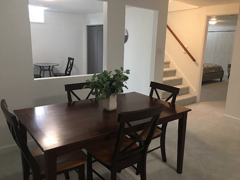 Entering the unit, and down the stairs, this picture is a great overall view of the apartment, with the living room just behind the formal dining area. The bedroom's six panel door closes to create a private suite.