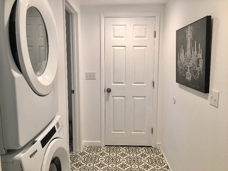 Located just outside the bathroom, the stacked Whirlpool washer and dryer make doing laundry a breeze. The closed solid wood door leads to the 150 square foot storage room.