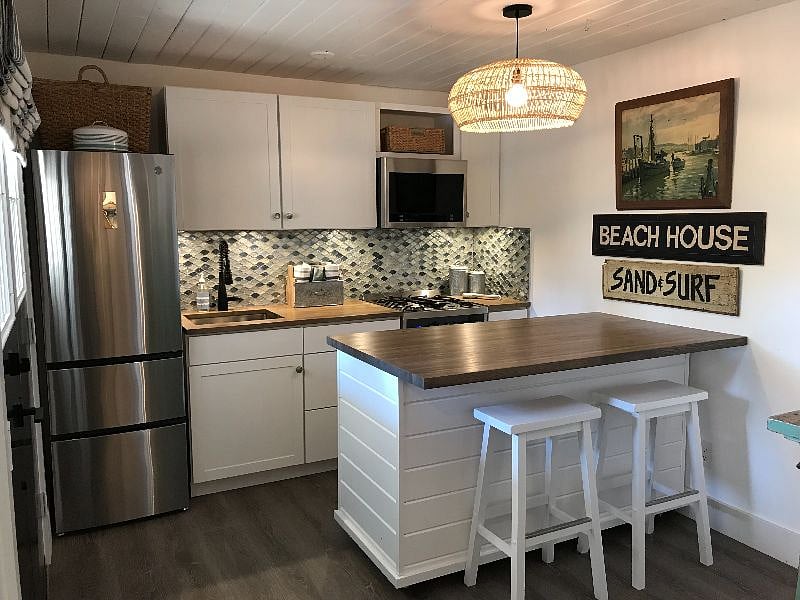 Kitchen with all new stainless steel appliances. Island on wheels.