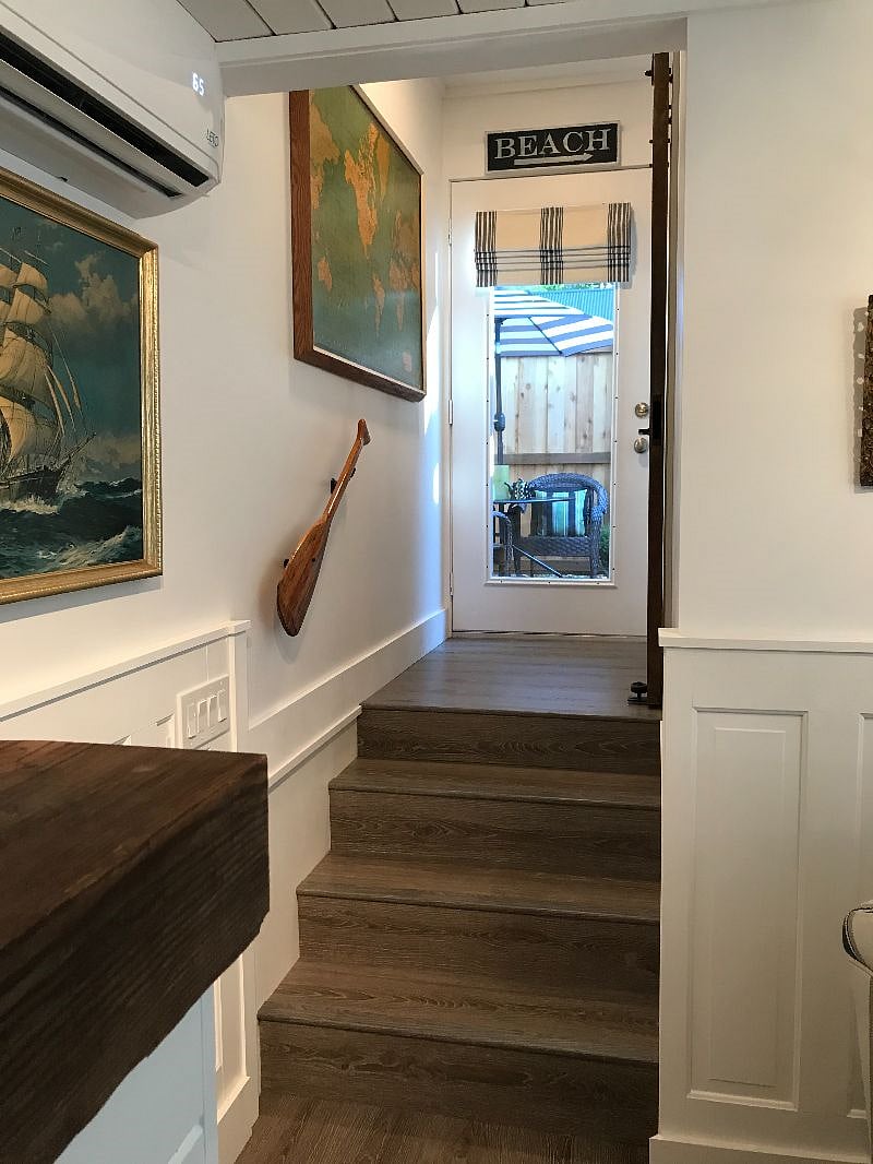 Stairs to outdoor patio, main bathroom and washer/dryer.