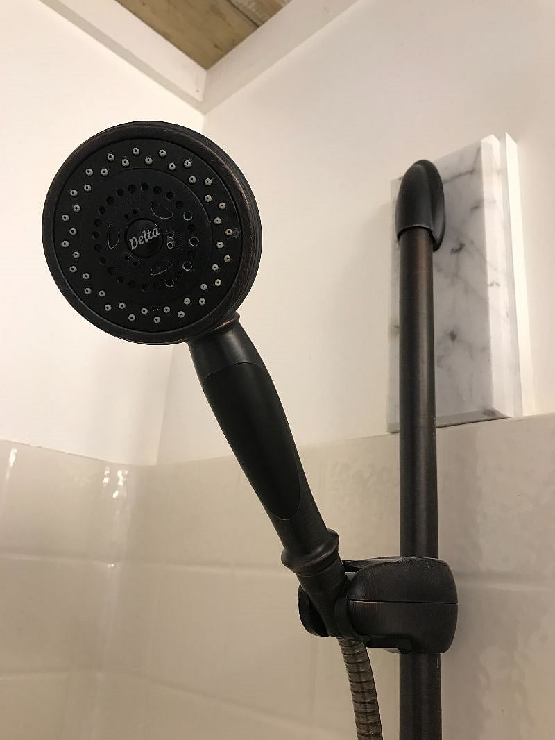 Delta massage shower head with slide bar in main bathroom.
