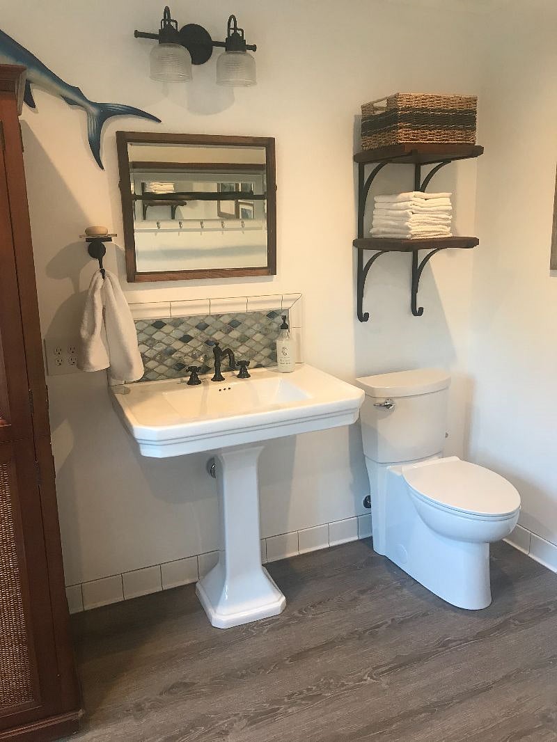 Upstairs bathroom with armoire and closet area.