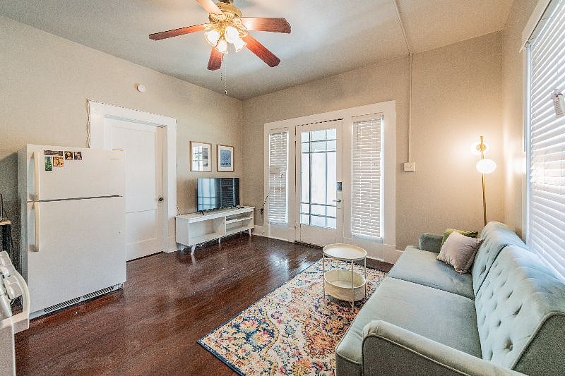 View of living room and refrigerator, door to bedroom