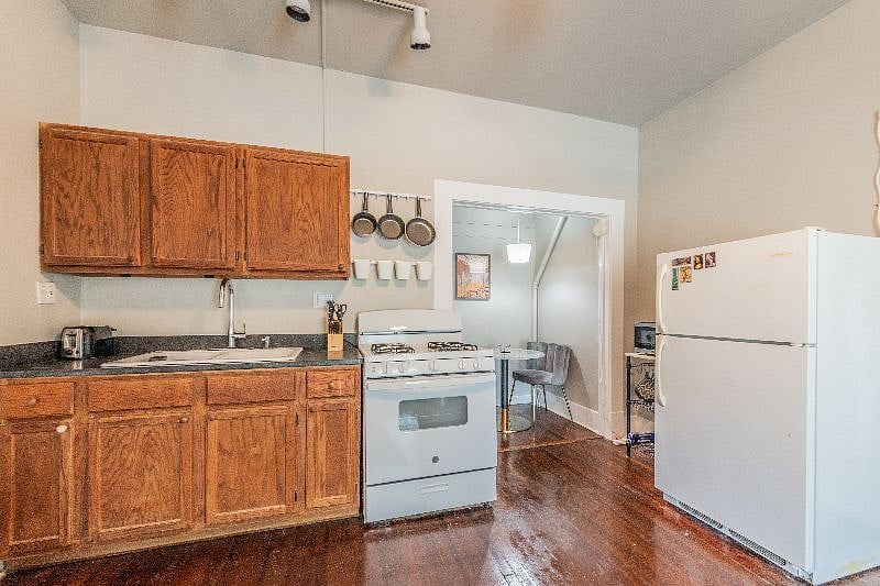 Kitchen with granite countertop, new faucet fixture, new gas range, microwave cart with coffeemaker, toaster