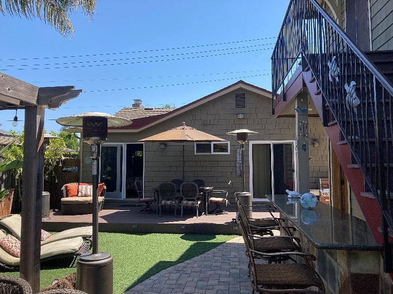 Oasis backyard includes access to the hot tub, fire pit, grill, and seating for meals with friends.