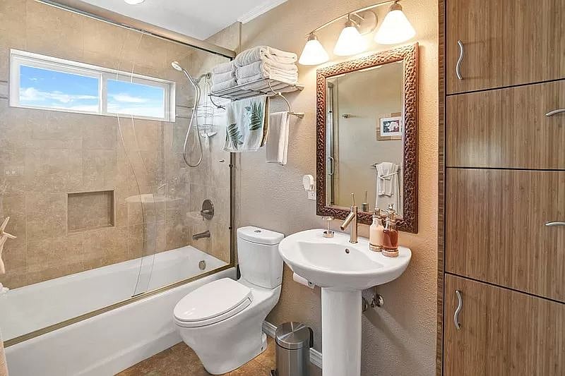 Well appointed bathroom has tub/shower and plenty of storage.