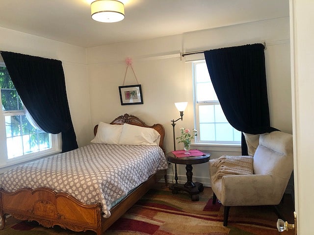 Lower private bedroom with elegant fully black-out curtains. A TV sits atop an opposing console table. It can be moved, upon request. Please treat the antique objects in this room with care and respect for their history.