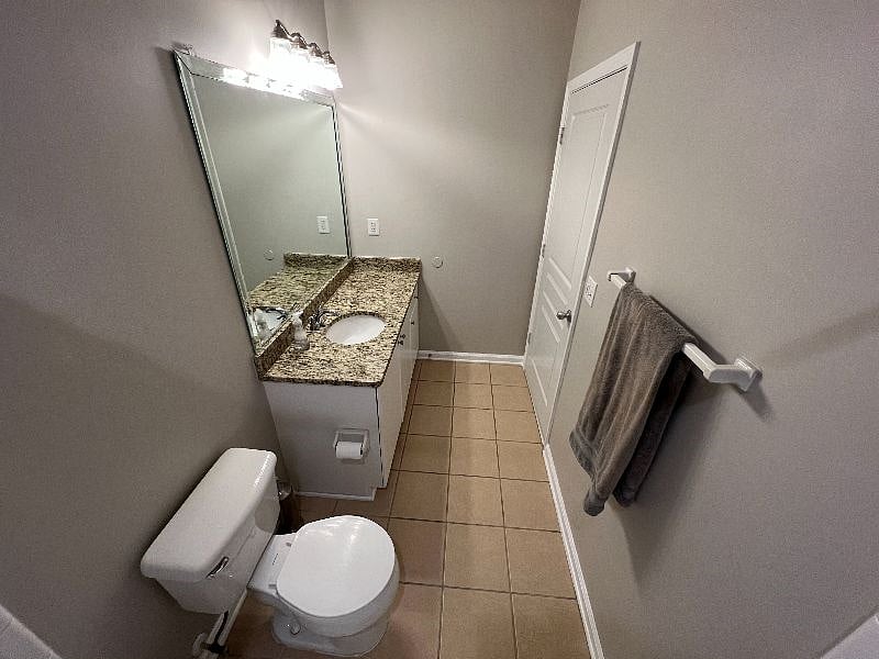 Brightly lit bathroom is long and spacious.