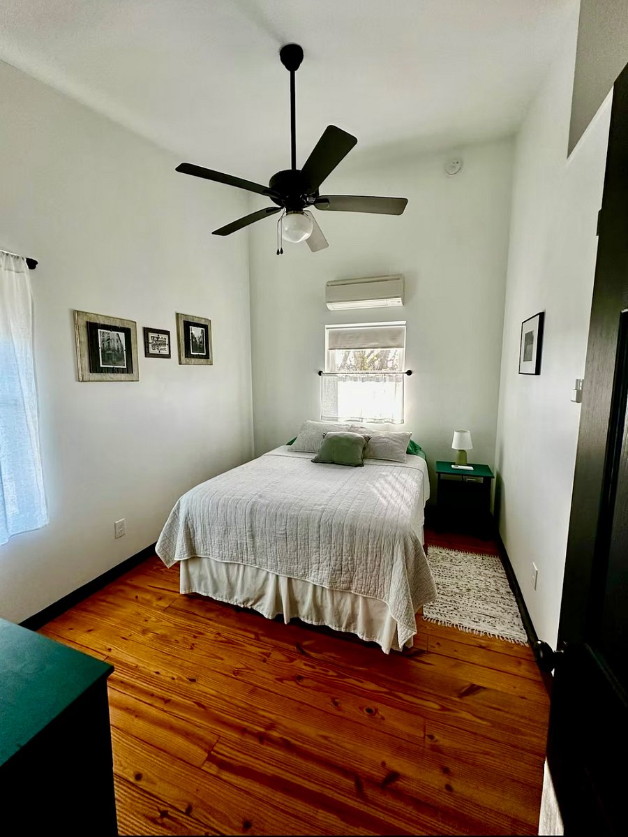 Upstairs bedroom #1 with lofted ceiling, queen-size bed, large closet, nightstand, 6-drawer dresser, ceiling fan, smart TV, and mini-split AC/heating for customized sleeping comfort
