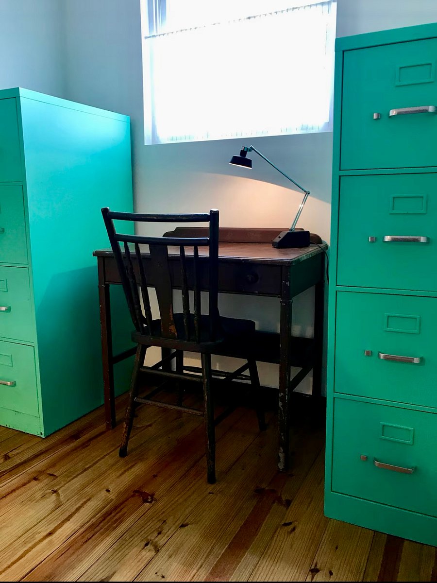 Vintage schooldesk provides additional work space, and filing cabinets provide extra storage
