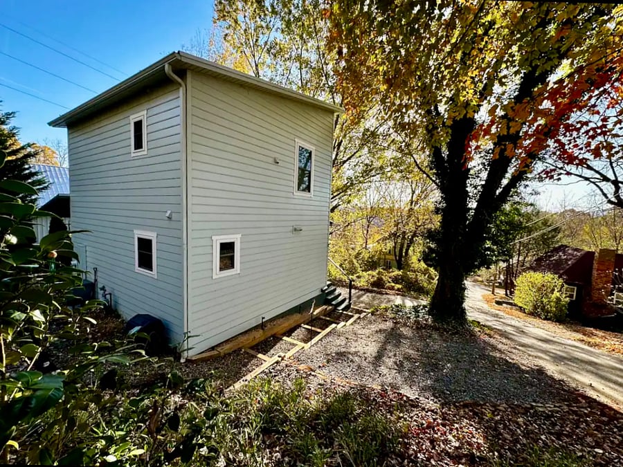 Driveway plus gravel parking pad adjacent to house provides parking for 3 cars