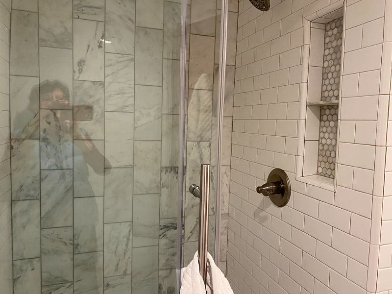 The glass doored shower completes the beautiful marble bathroom.
