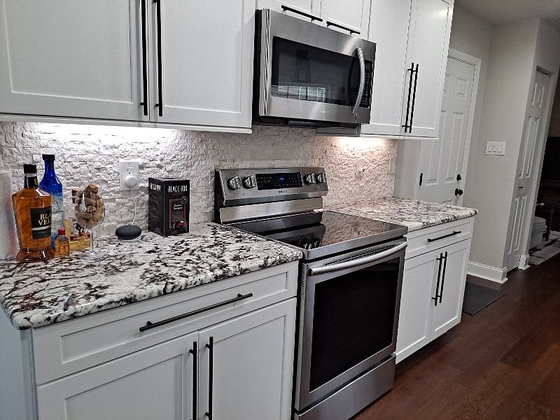 Kitchen has all new cabinets, backsplash, counter tops, appliances, and floor covering.