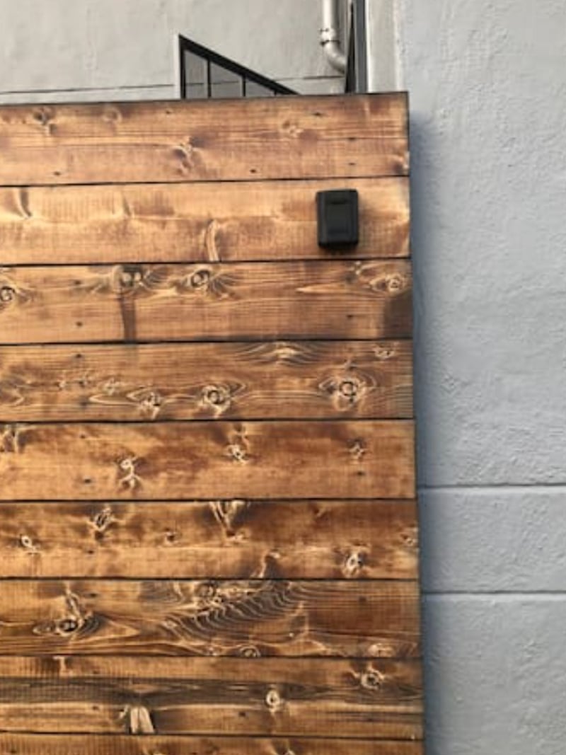 The private entryway door (backyard side gate) to the unit, with keypad lock.