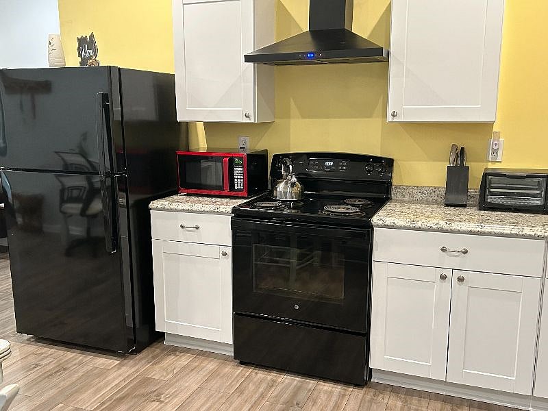 kitchen fully equipped with a refrigerator, electric stove, dishwasher, microwave, toaster oven, blender and much more