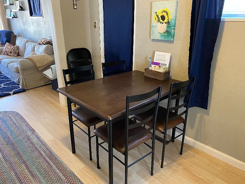 Dining room with high ceiling between the living room and kitchen. The table has seating for 4.