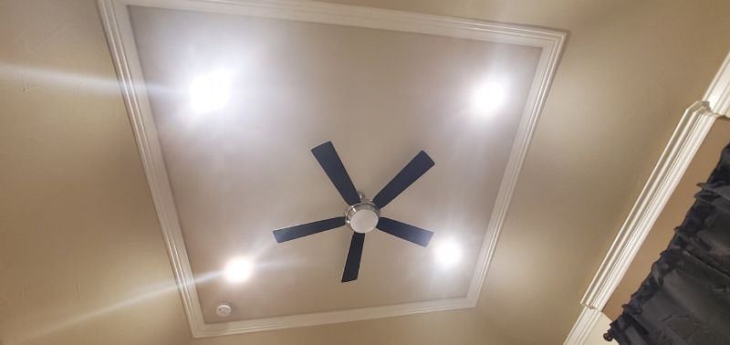 Artistic high rise ceiling with ceiling fan.