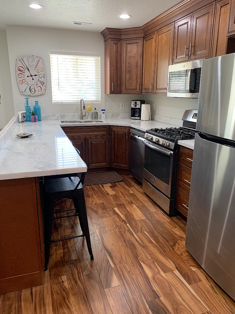 View into kitchen with marble counters and new cabinets with all stainless steel appliances, gas stove and all kitchen accroutrements provided.