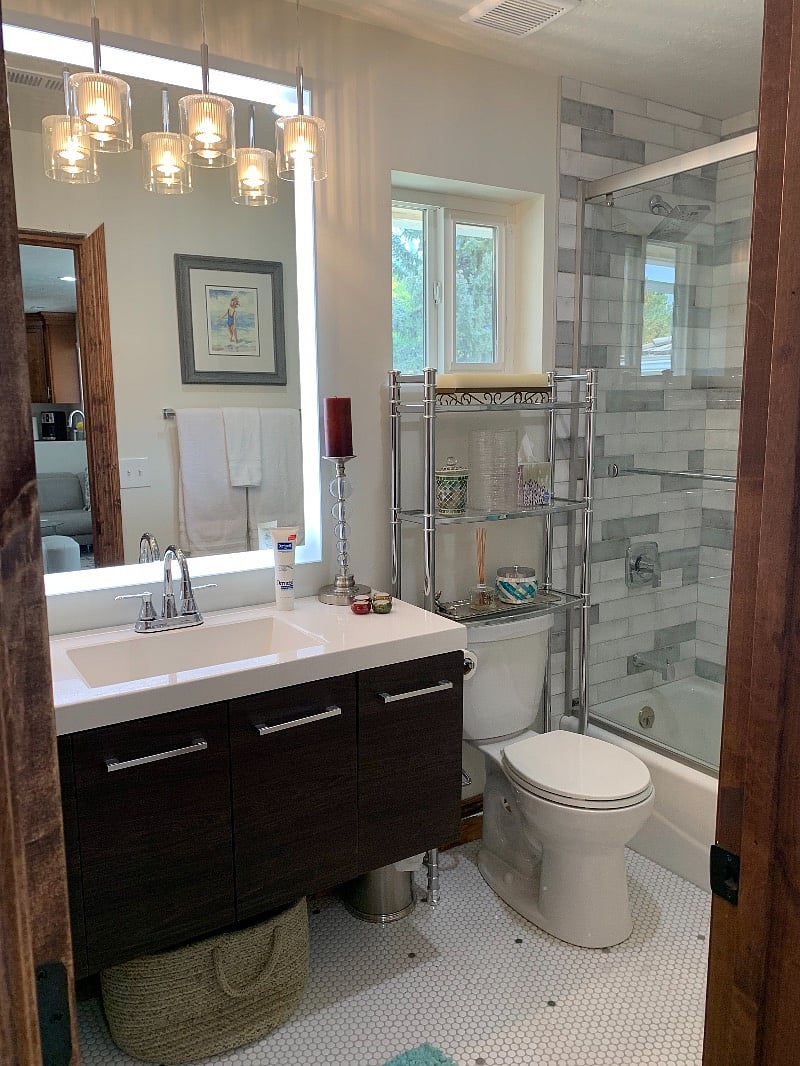 Bathroom with custom tile, lighted mirror and beautiful combination, tub and shower with sliding glass doors.