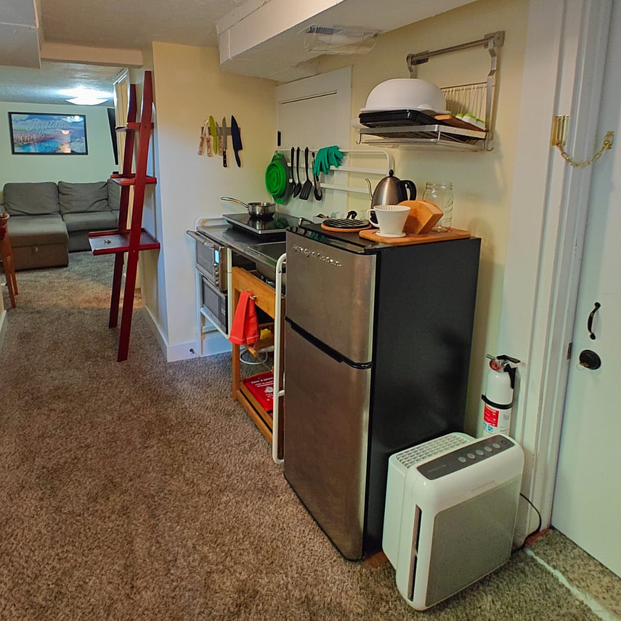 View from entry way through kitchen on the way to the bathroom, living room and west facing egress window equipped bedroom. The door on the right is for your private access to the laundry / bike / storage room.