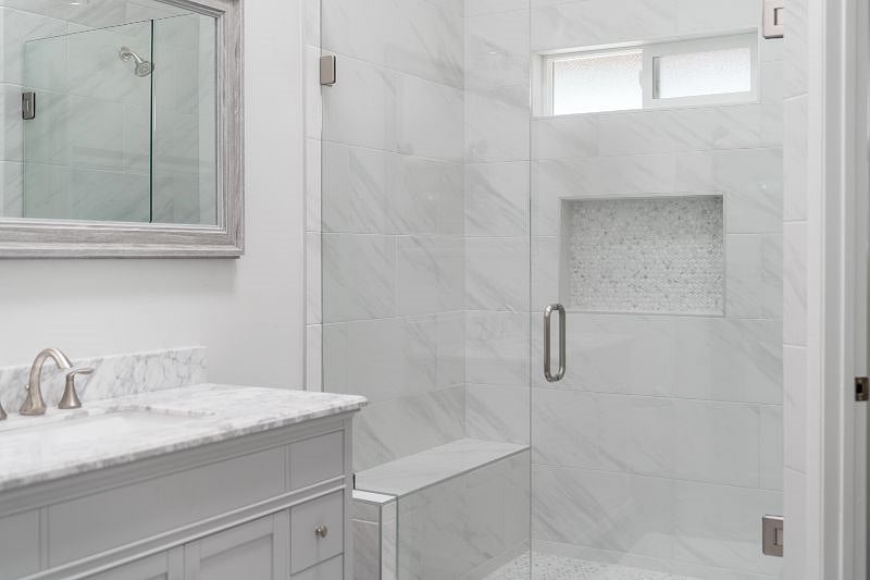 Master bath walk in shower enclosed in glass.