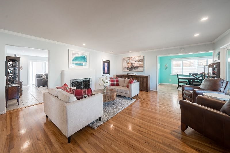 Large front sitting room with fireplace and beautiful surf art.